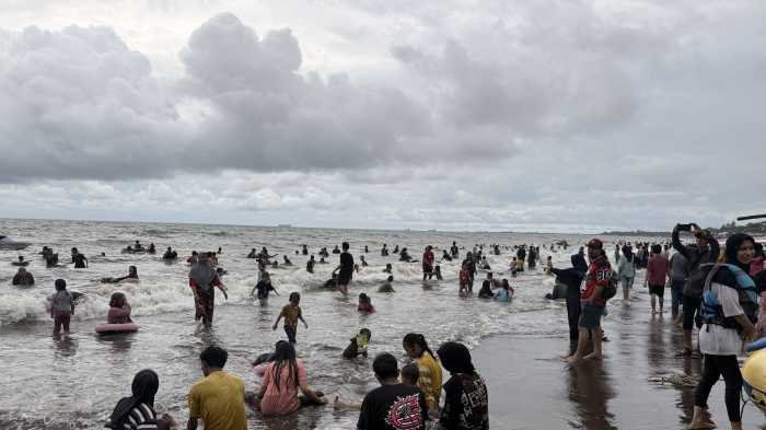 Meski Hujan dan Ombak Tinggi, Pantai Tanjung Bayang Tetap Diserbu Ribuan Pengunjung